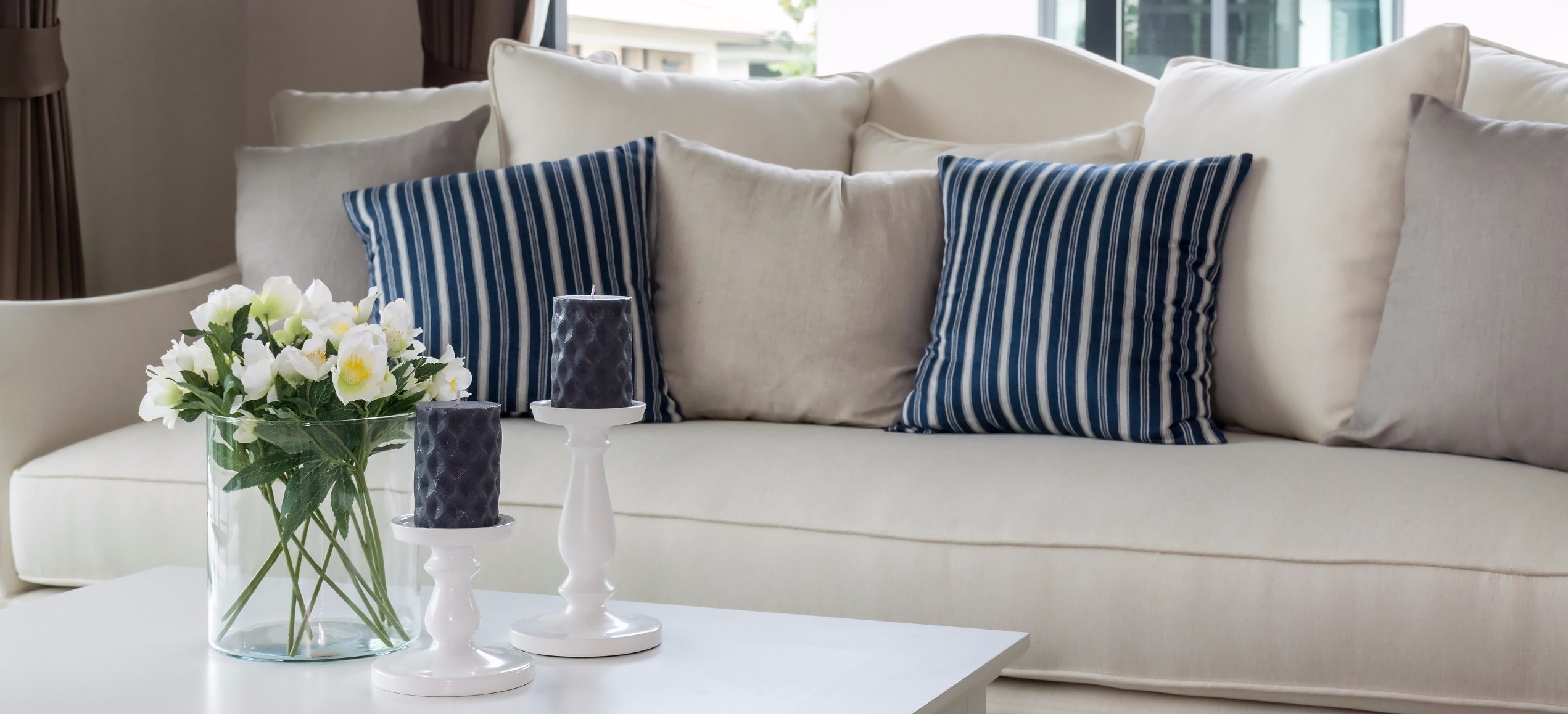 modern living room with glass vase and row of pillows on sofa